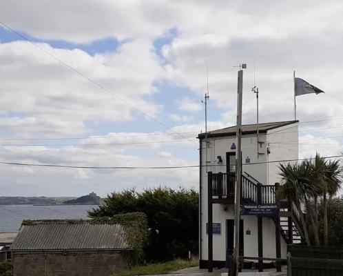 NCI Penzance Station's new Flag with St Michaels Mount in the background
