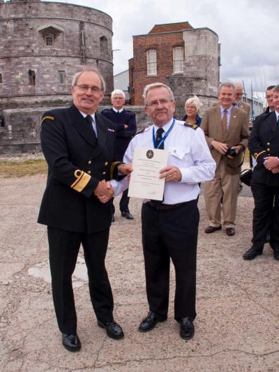 Chief Coastguard Peter Dymond OBE presents the DFS certificate to Station Manager Colin Lewis