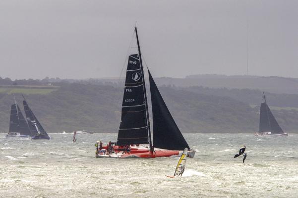 Wind surfers amongst large yachts at start of Fastnet Race