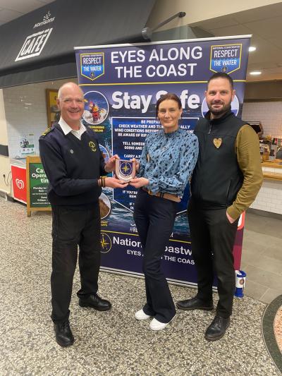 Station Manager Ian presents Morrisons Store Manager Michelle and Ops Manager Dean with the NCI Gwennap Head shield