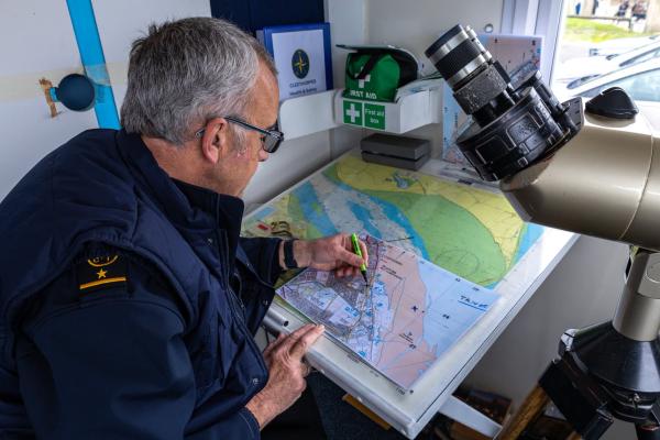 A watchkeeper plotting a position 